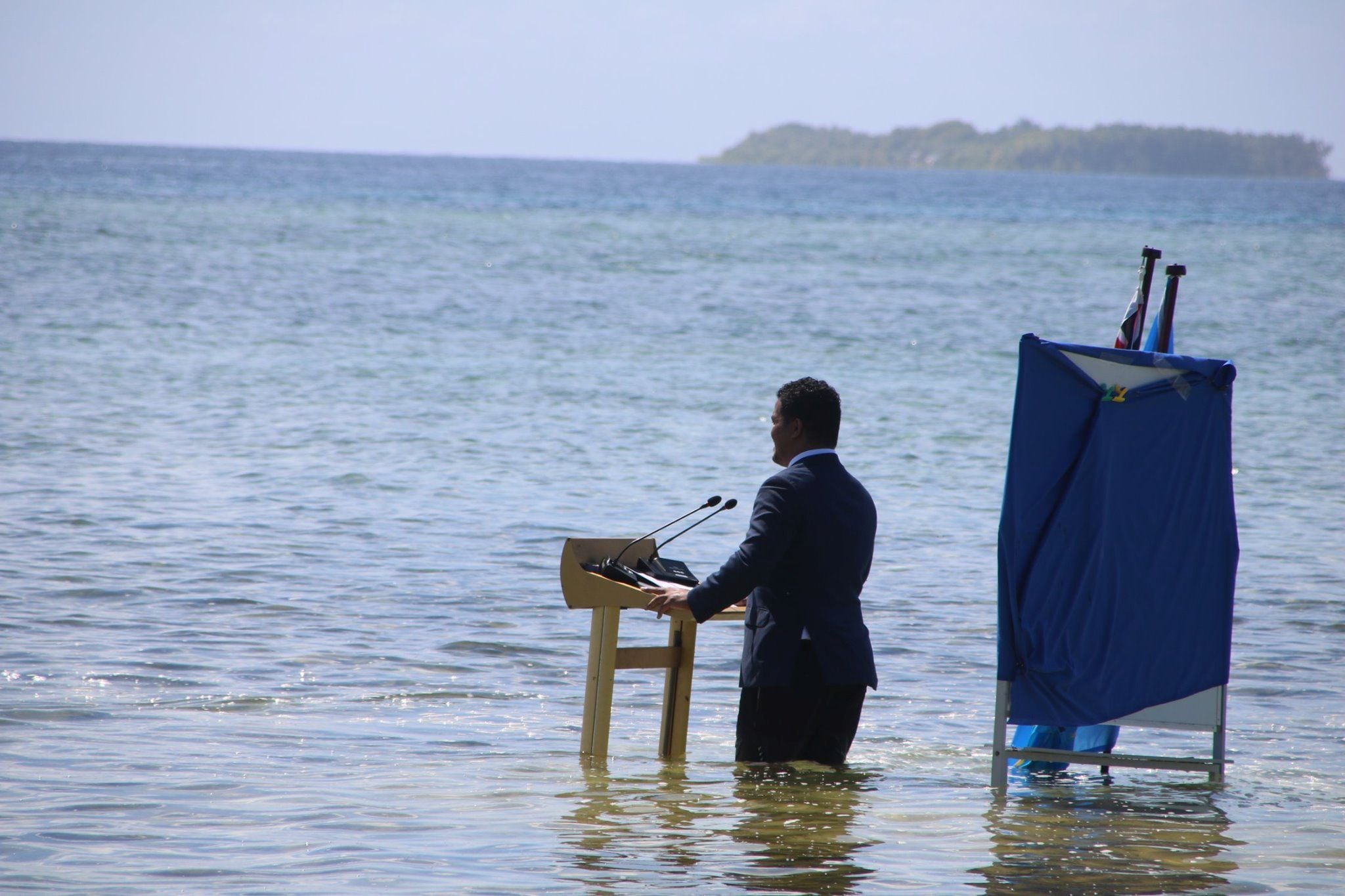 Tuvalu's Minister for Justice, Communication & Foreign Affairs Simon Kofe gives a COP26 statement while standing in the ocean in Funafuti