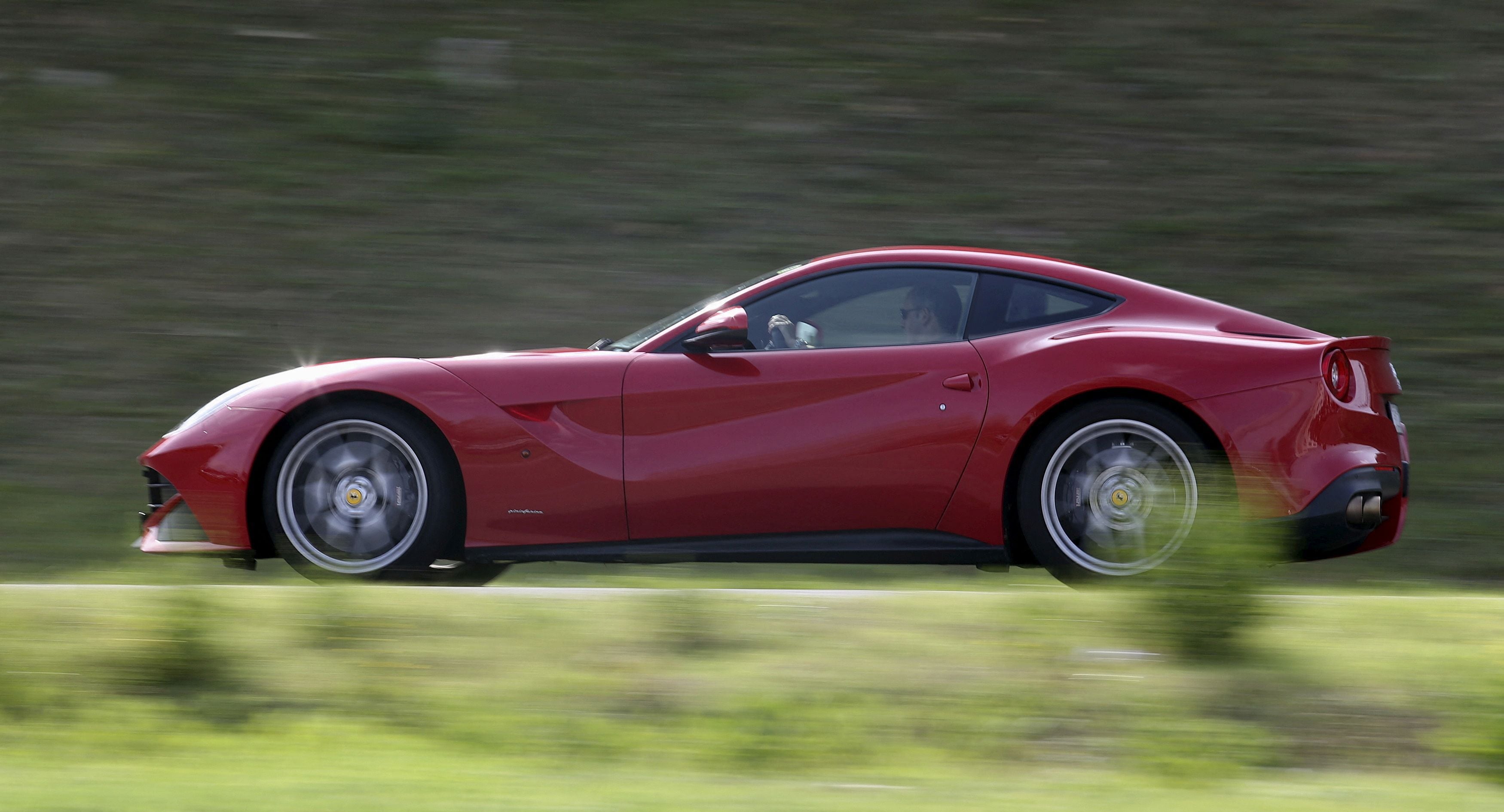 FILE PHOTO: A man drives a Ferrari luxury car in the Ferrari hometown in Maranello