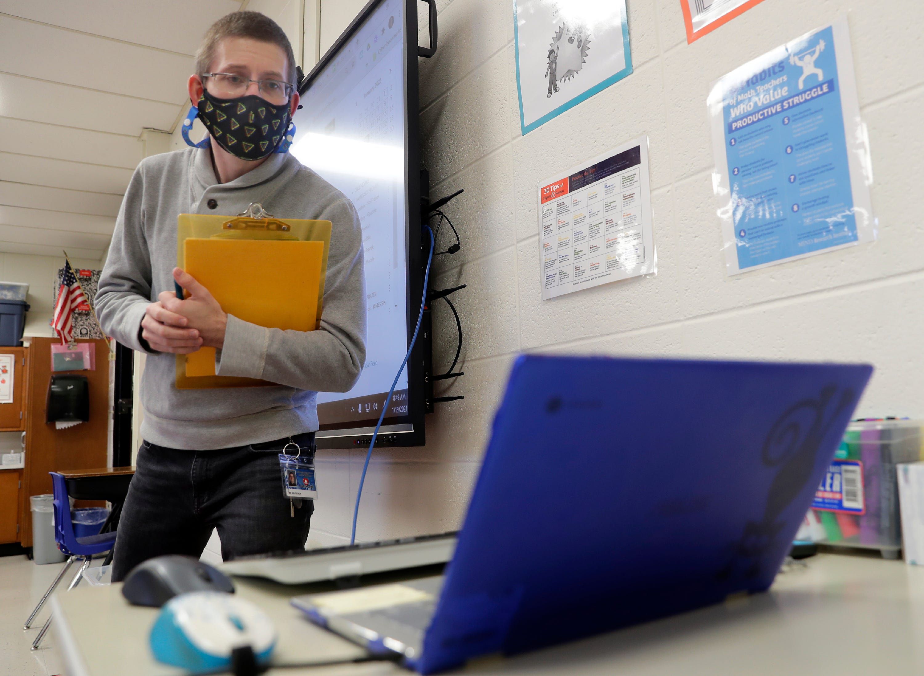 Fifth-grade teacher James Six-Fronek talks to online students as classes resume at Highlands Elementary School on Tuesday, Jan.