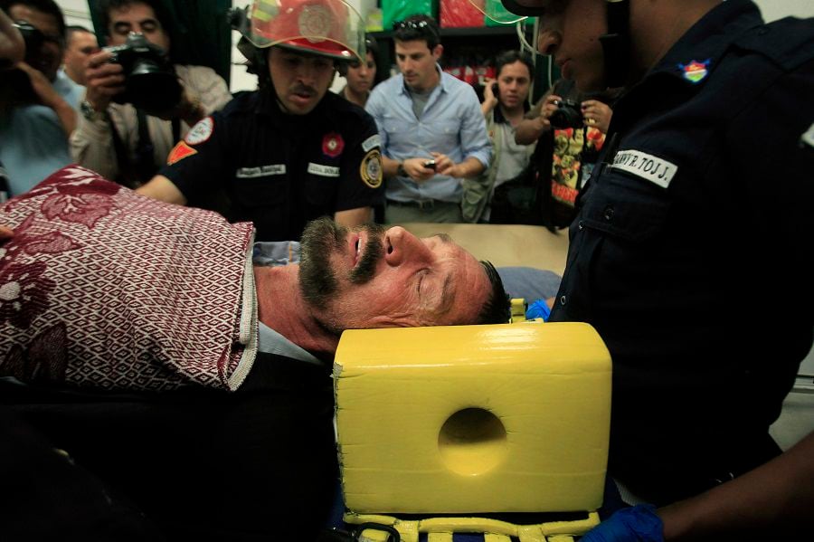 U.S. anti-virus software guru John McAfee is seen lying in a stretcher as he is transferred by paramedics at the Policia Nacional Civil hospital in Guatemala City