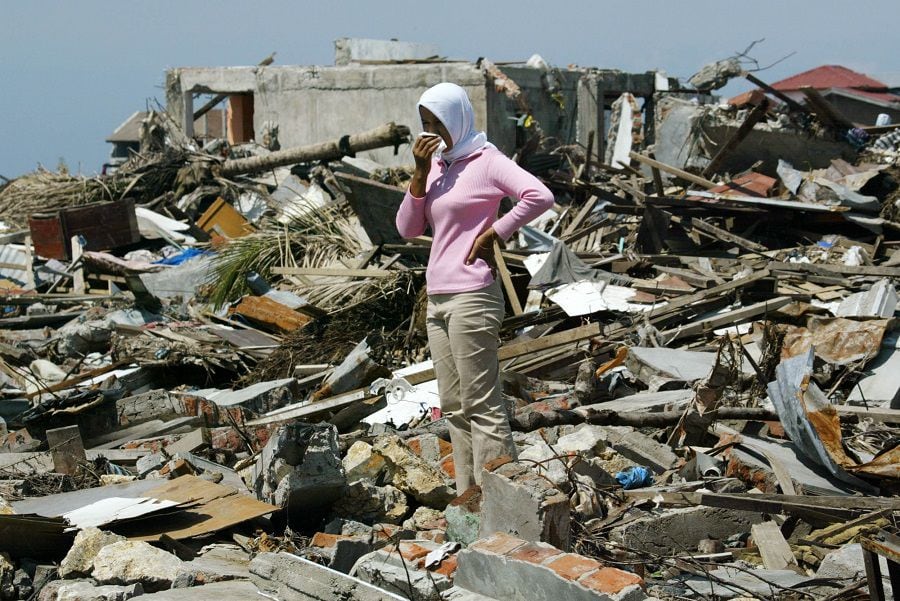 An Achenese woman stands alone amid debris in the tsunami-devastated city of Banda Aceh.