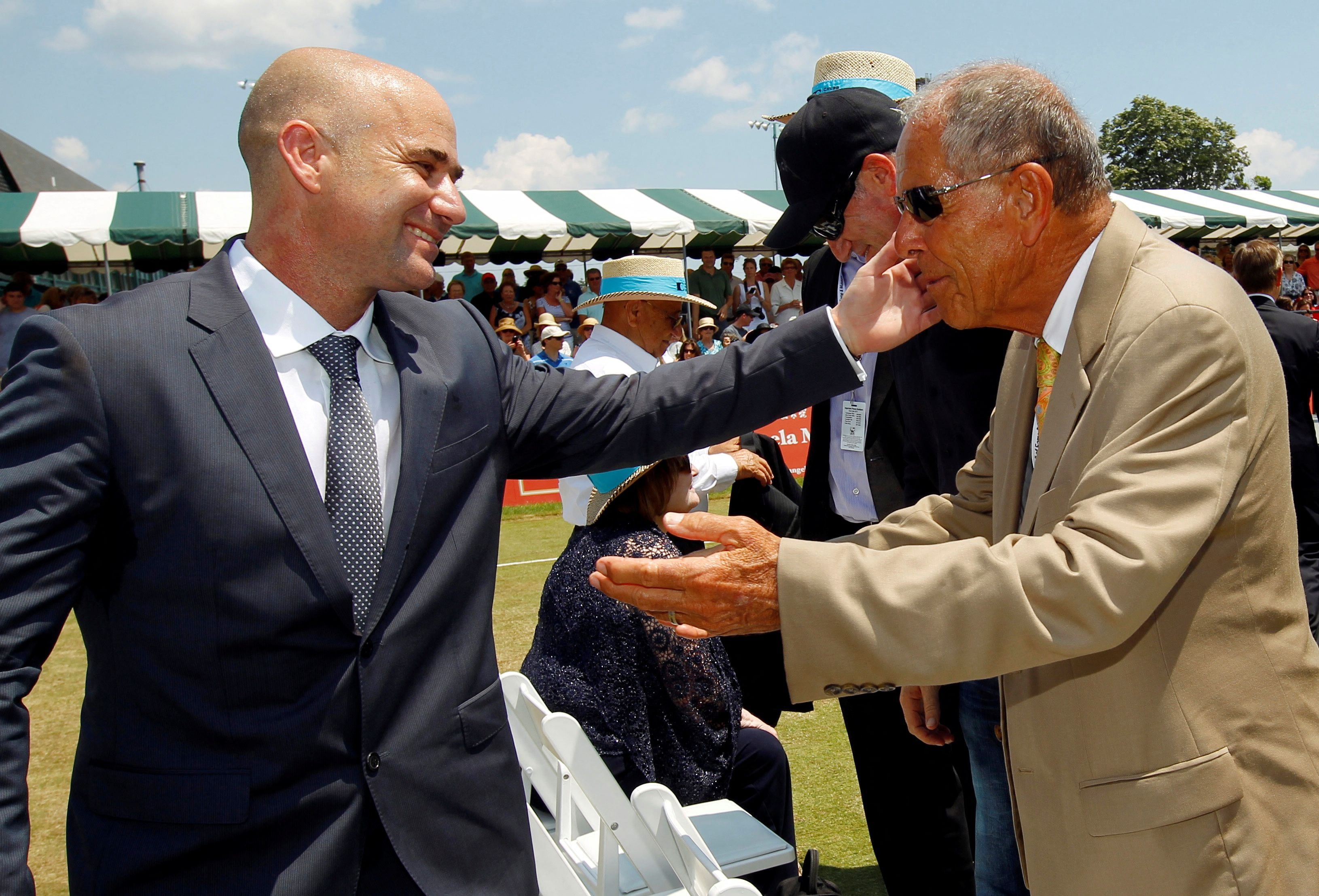 FILE PHOTO: Andre Agassi hugs coach Nick Bollettieri after Agassi was inducted into the International Tennis Hall of Fame in Newport