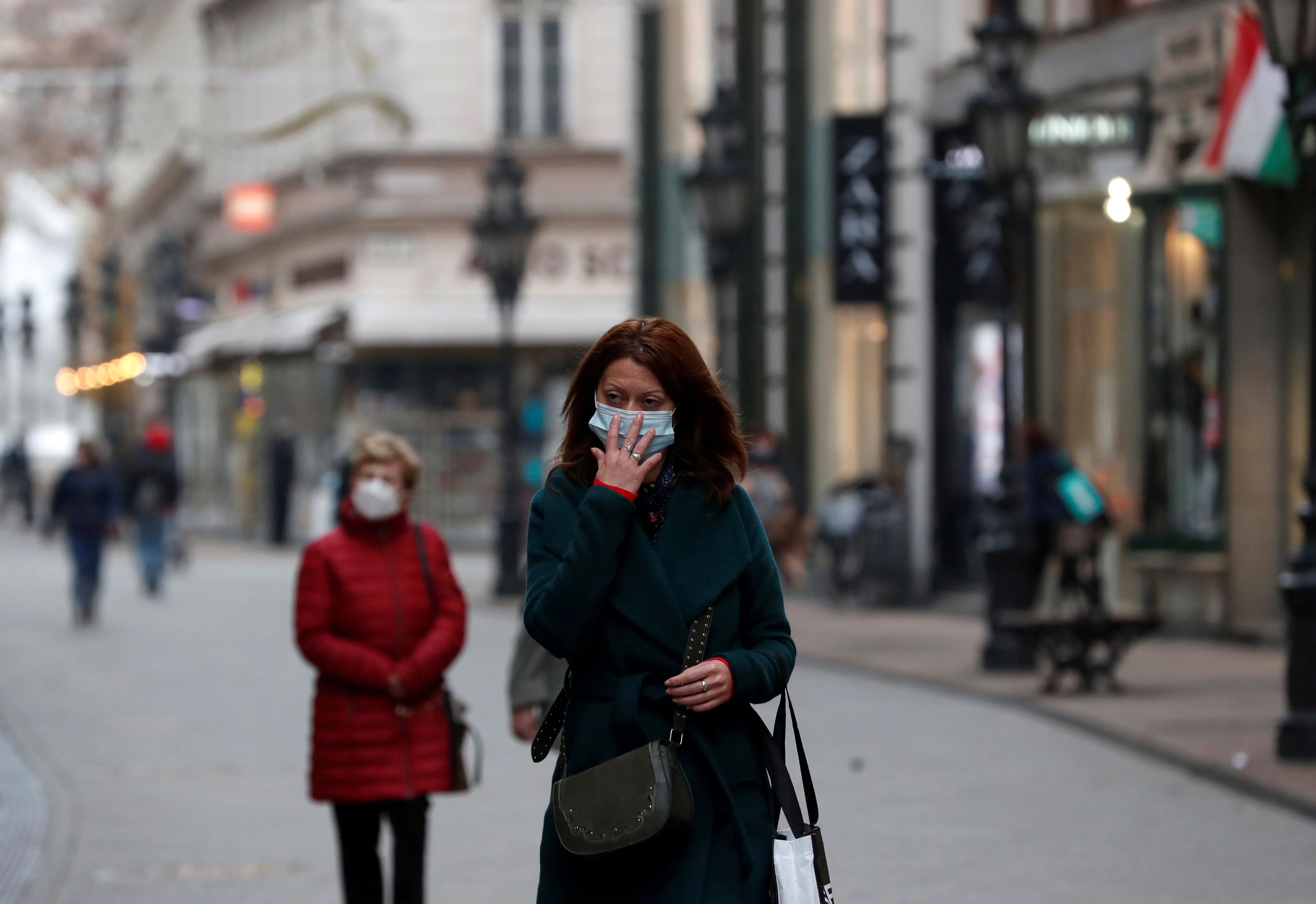 FILE PHOTO: People wearing protective face masks walk in downtown Budapest