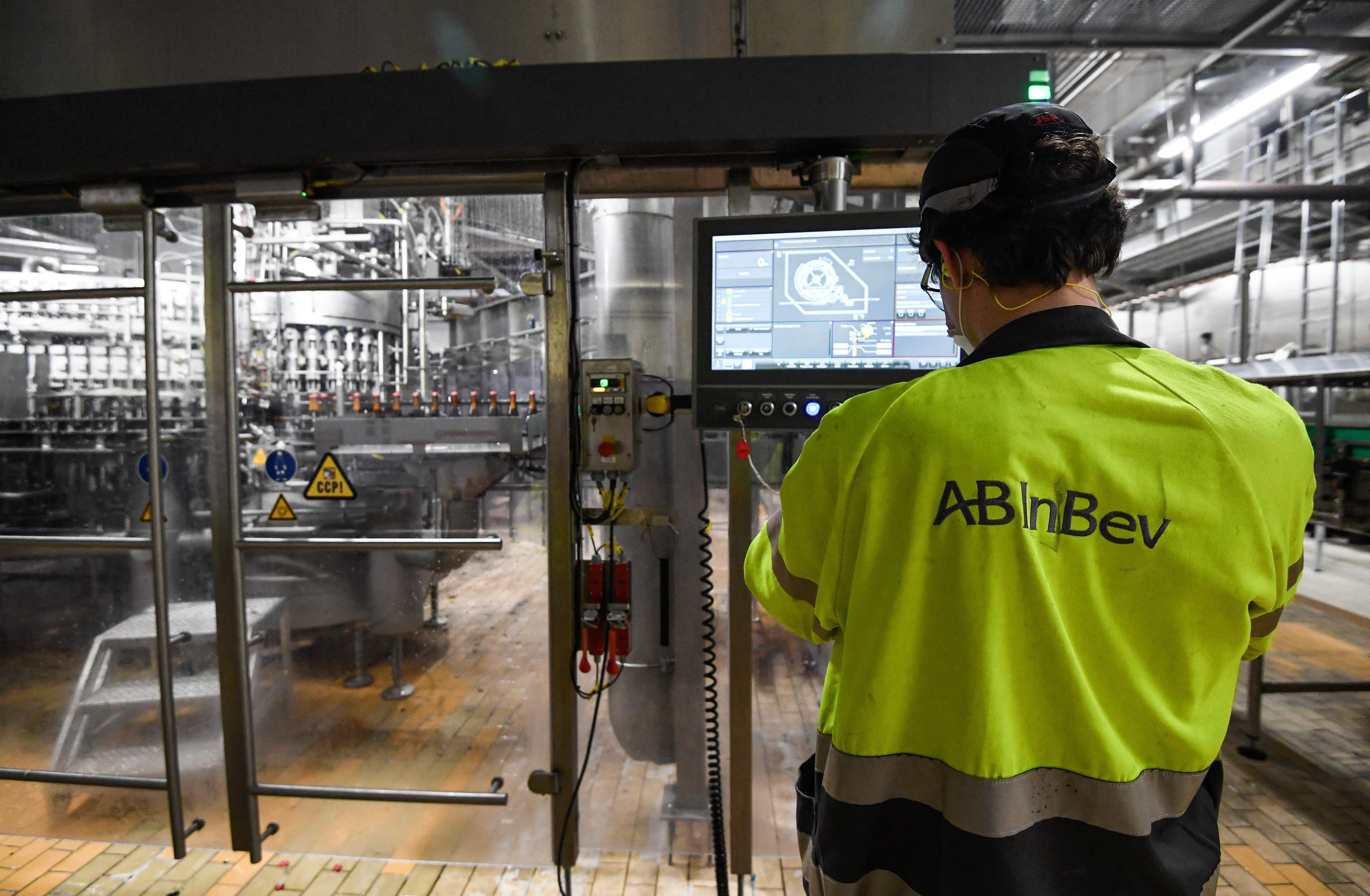 Un trabajador monitoreando la línea de producción de botellas en la fábrica de Stella Artois, en Lovaina. Foto: AFP.