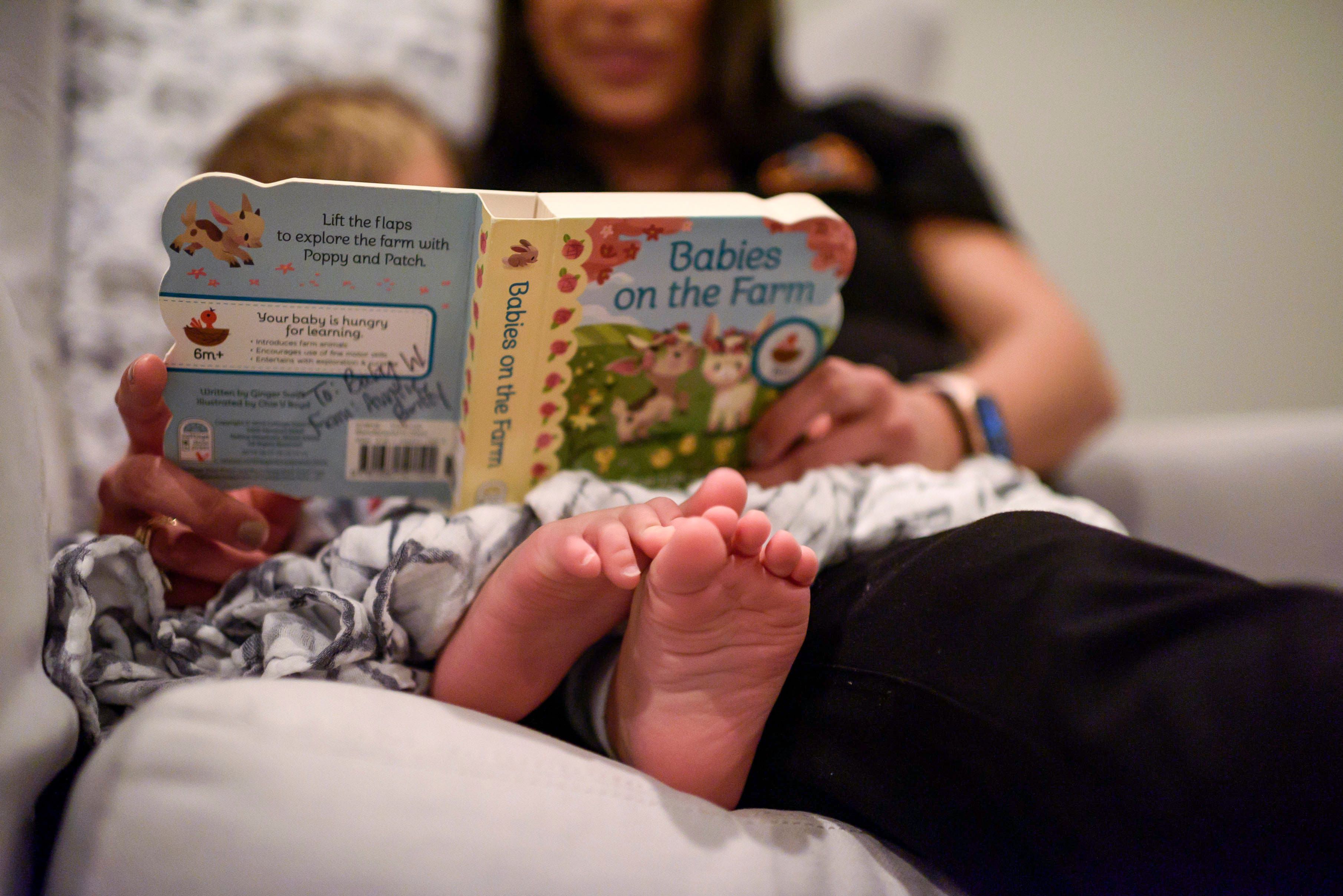 Heather and Hampton snuggle up together in their reading chair to flip through a picture book called    Babies on the Farm,