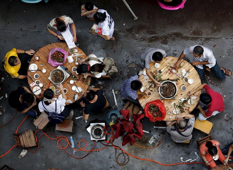 People eat dog meat at a dog meat restaurant district on the day of local dog meat festival in Yulin