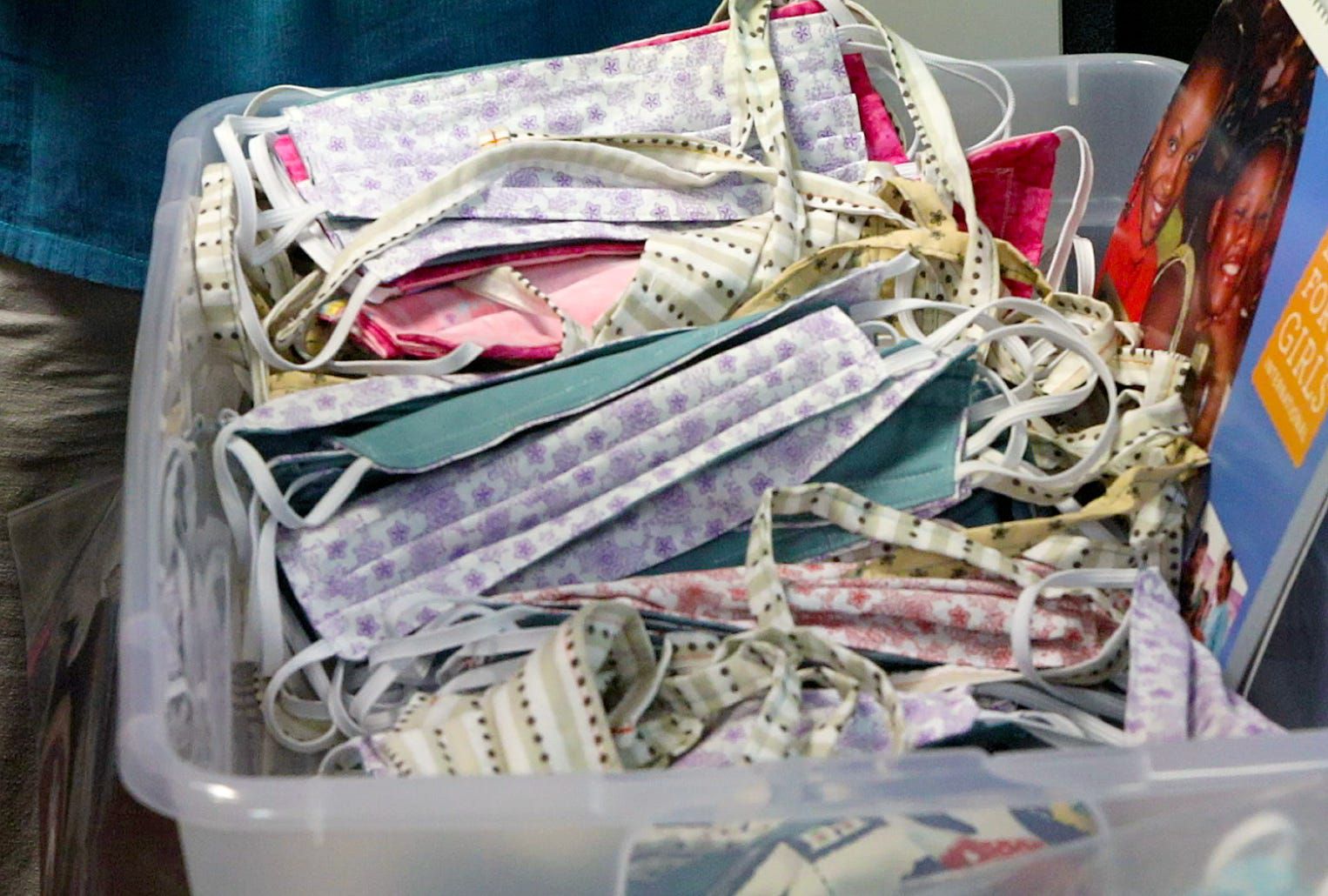 A bin of completed face coverings sewn by volunteers of the Gainesville chapter of Days For Girls International is shown on