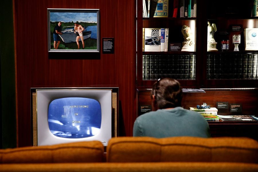 A visitor watches footage from the moon landing in a recreated 1960s-style living room at the "Destination Moon: The Apollo 11 Mission" exhibit at the Museum of Flight in Seattle