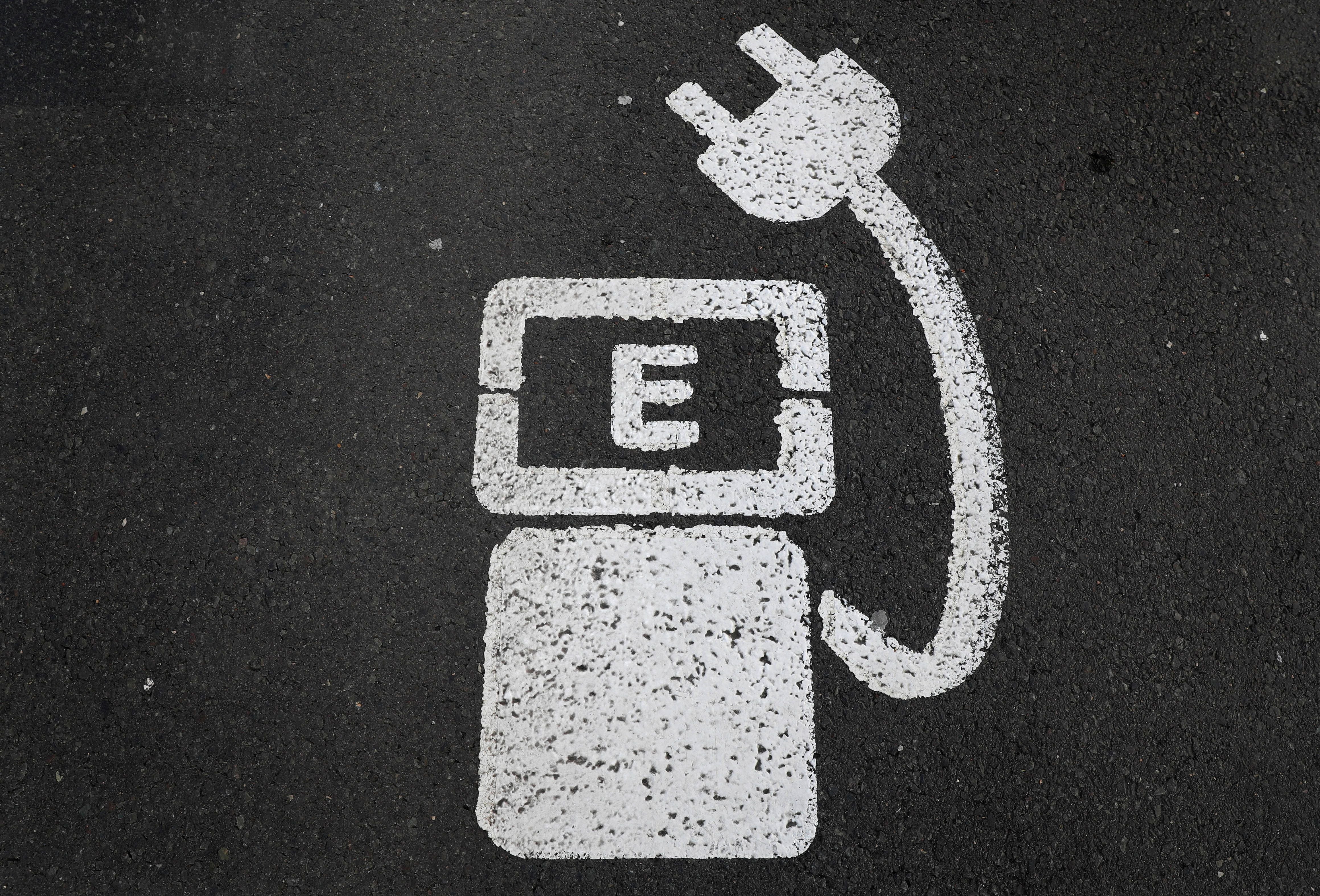 FILE PHOTO: A battery charger sign for electric cars is painted on the ground of a parking ground near the soccer stadium in Wolfsburg