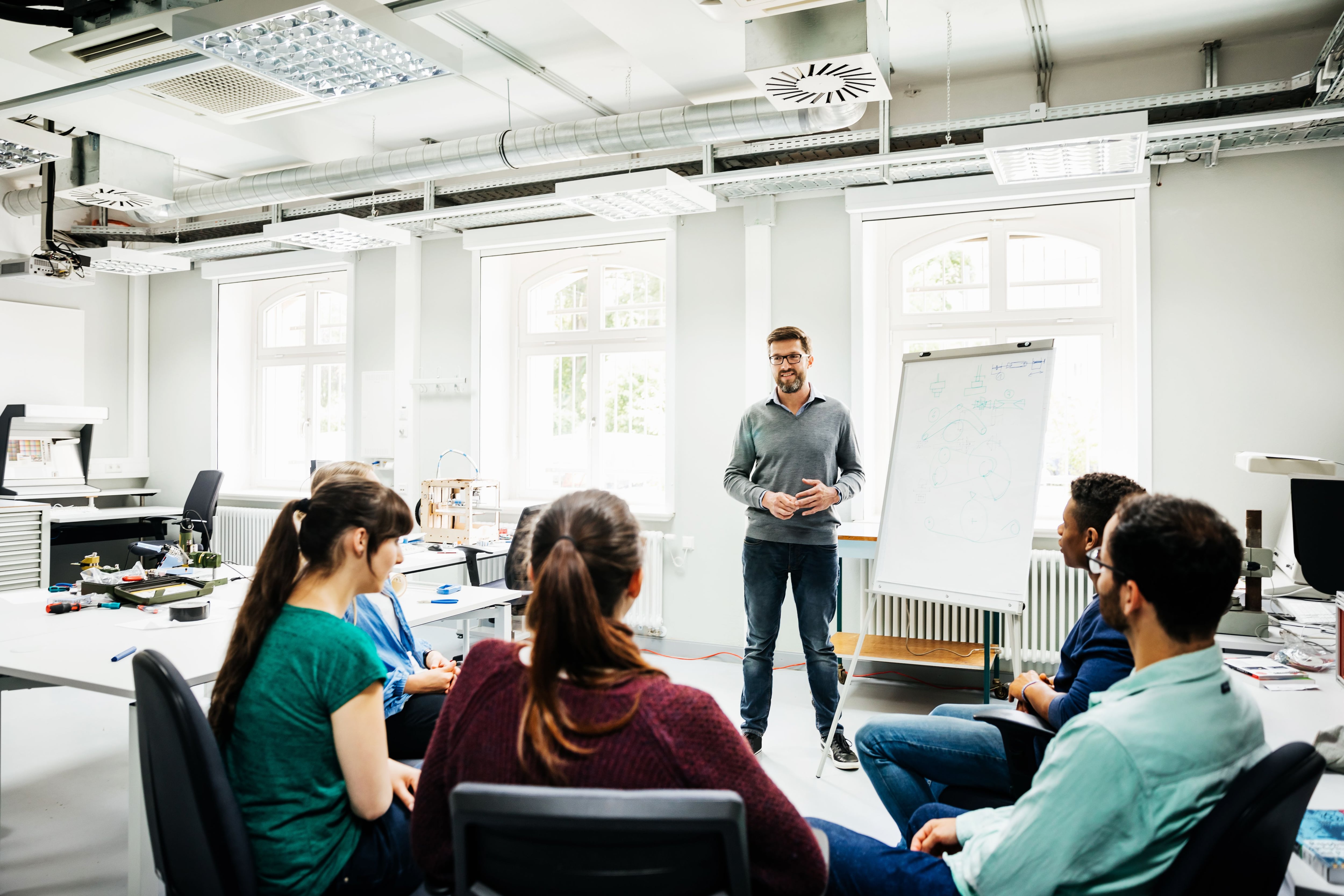 University Tutor Speaking To Students During Seminar