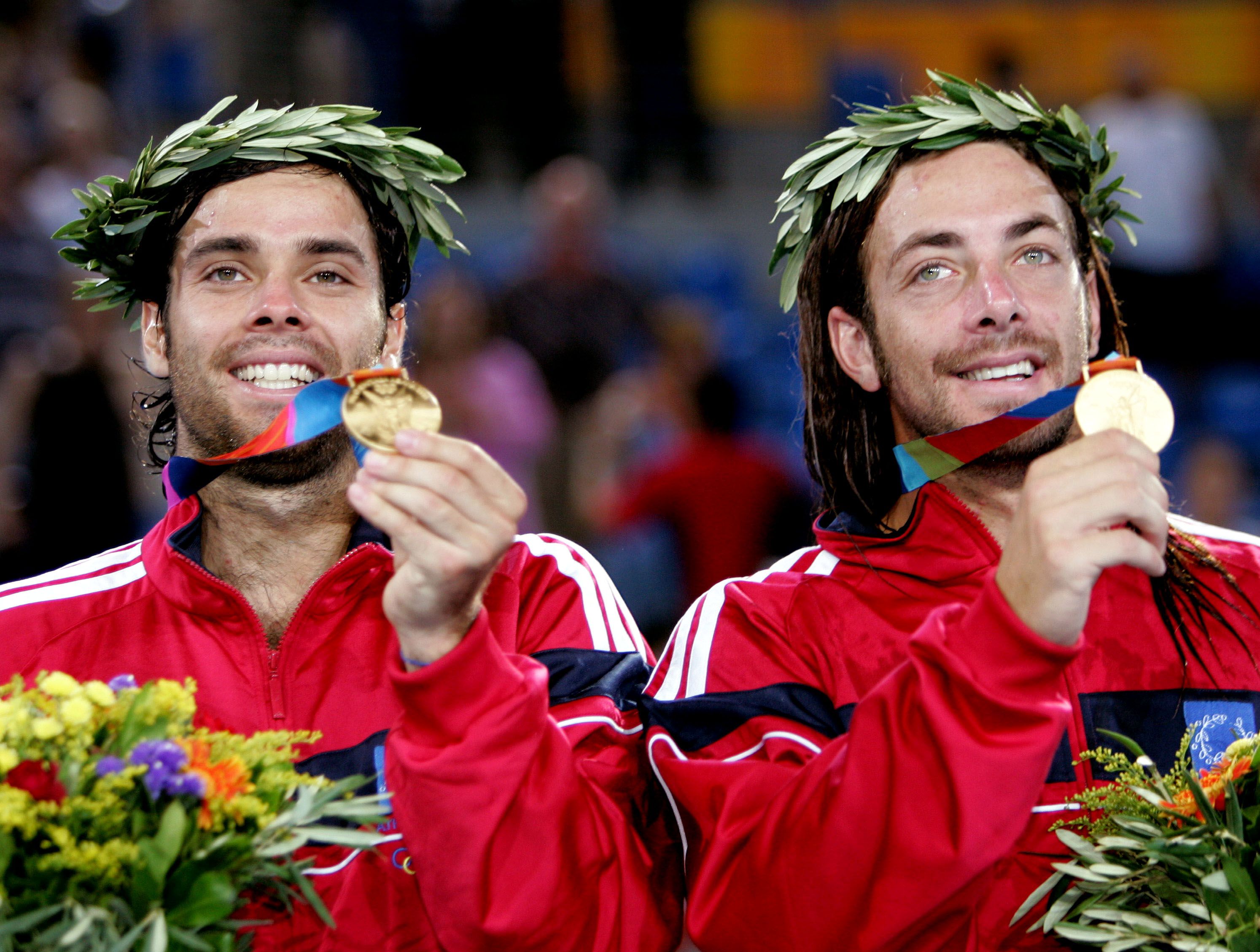 Chile's Nicolas Massu (R) and Fernando Gonzalez (L) show their gold medals while up on the podium af..