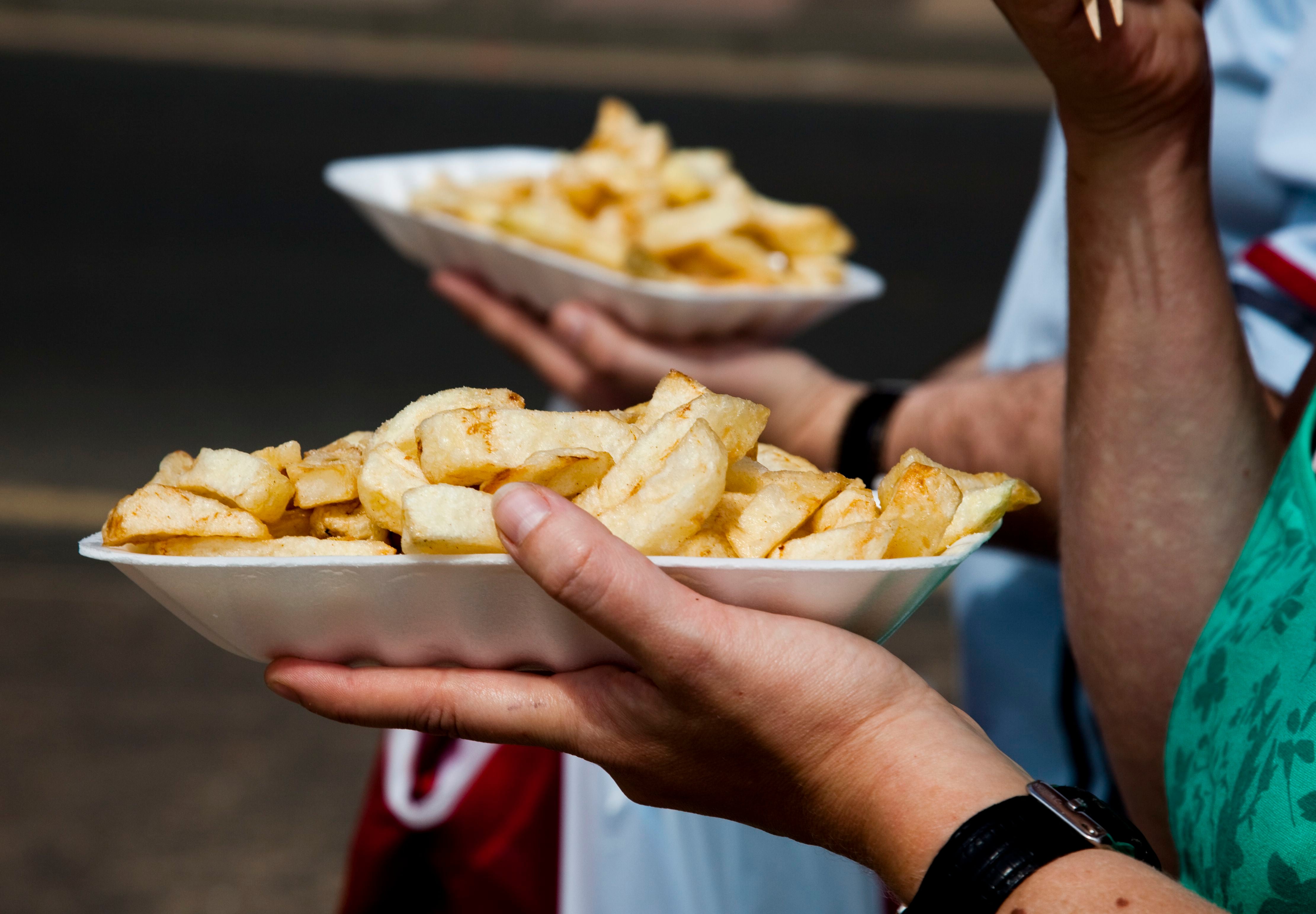 People eat chips whilst walking along the promenade at the British holiday resort of Scarborough