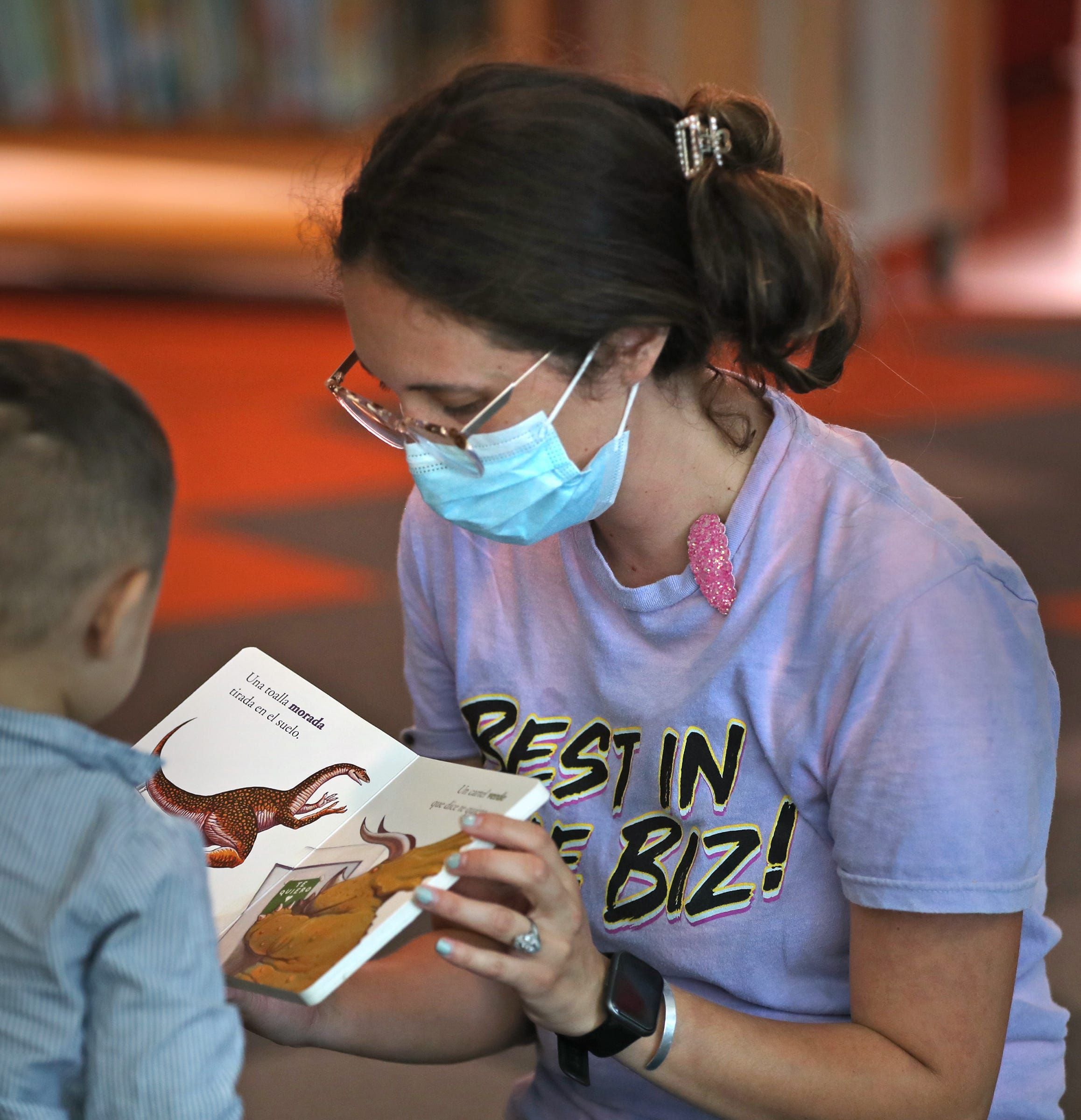 Noemi Rogers, right, helps read a book Wednesday, Sept. 8, 2021 at the Central Library of the Indianapolis Public Library. Masks