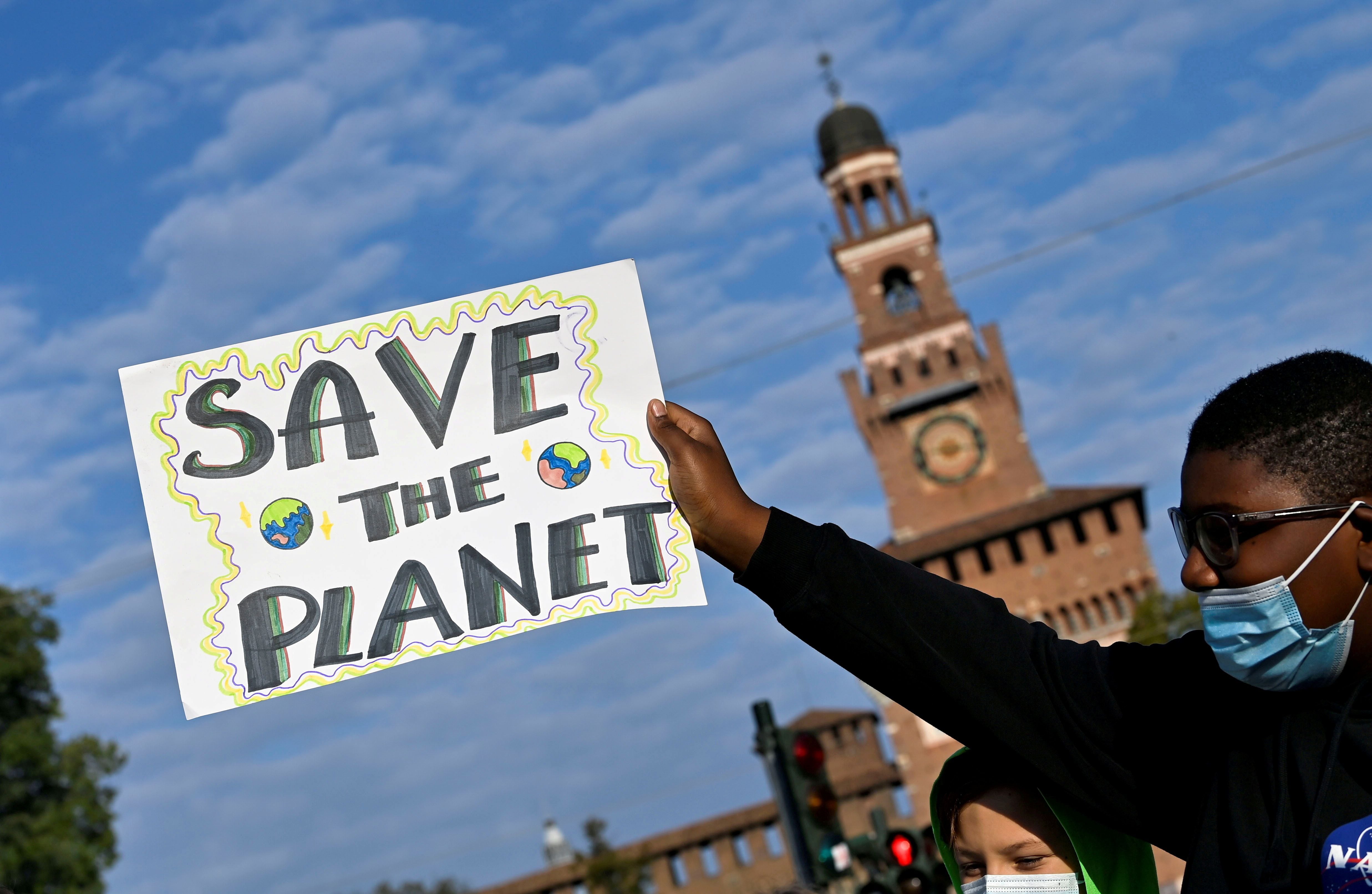 FILE PHOTO: A demonstrator holds up a sign as he attends a Fridays for Future climate strike in Milan, Italy ahead of Glasgow's COP26 meeting