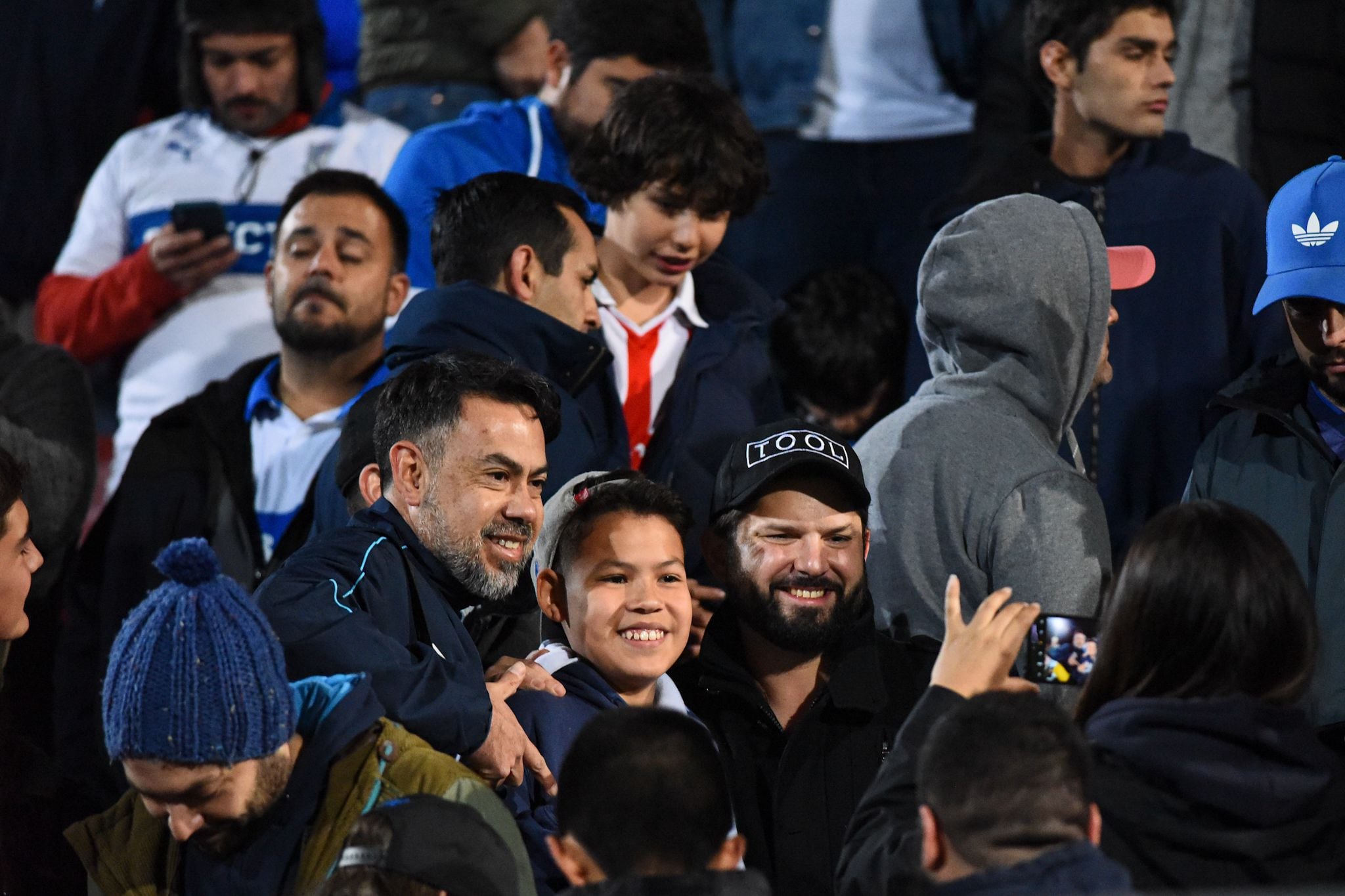 El presidente Gabriel Boric retratándose con los hinchas que le pidieron una foto.