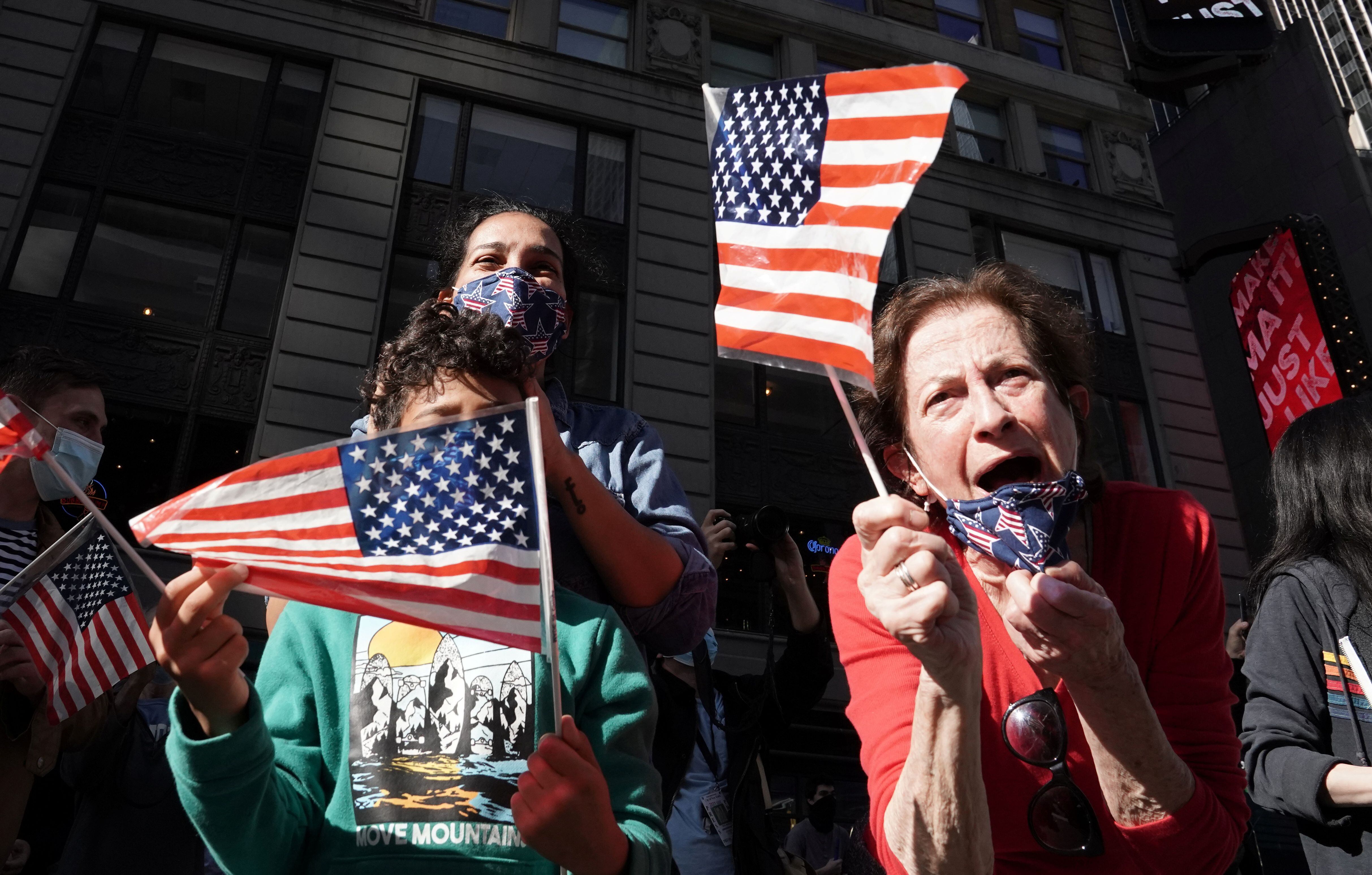 People react as media announce that Democratic U.S. presidential nominee Joe Biden has won the 2020 U.S. presidential election, on Times Square in New York City