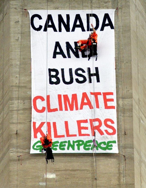 Greenpeace activists Chris Holden (top) and Steven Guilbeault hang from cables near the the top of T..