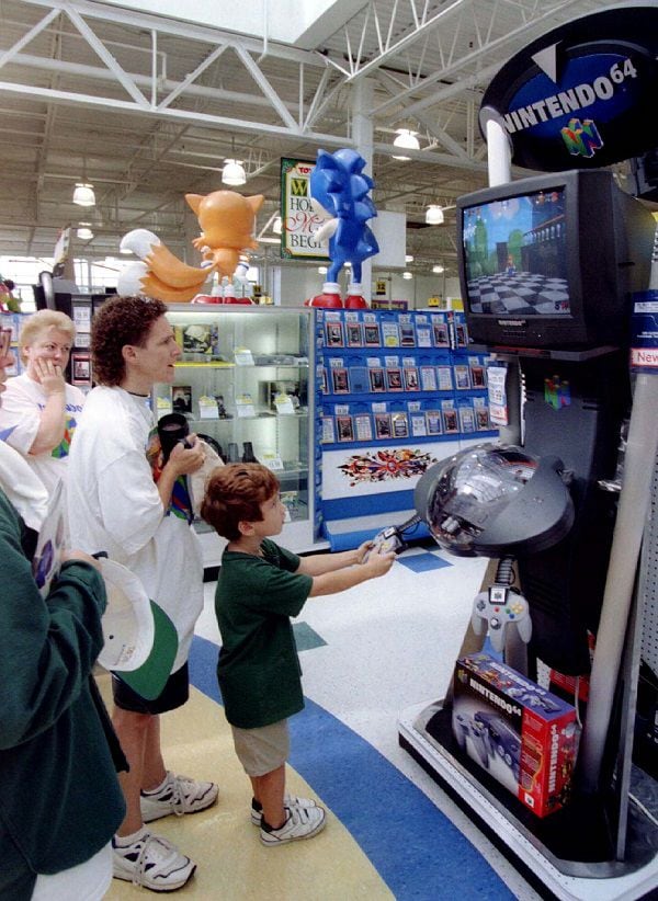 A youngster tries Nintendo newest video game player N64as others wait their turn at the Toys R Us st..