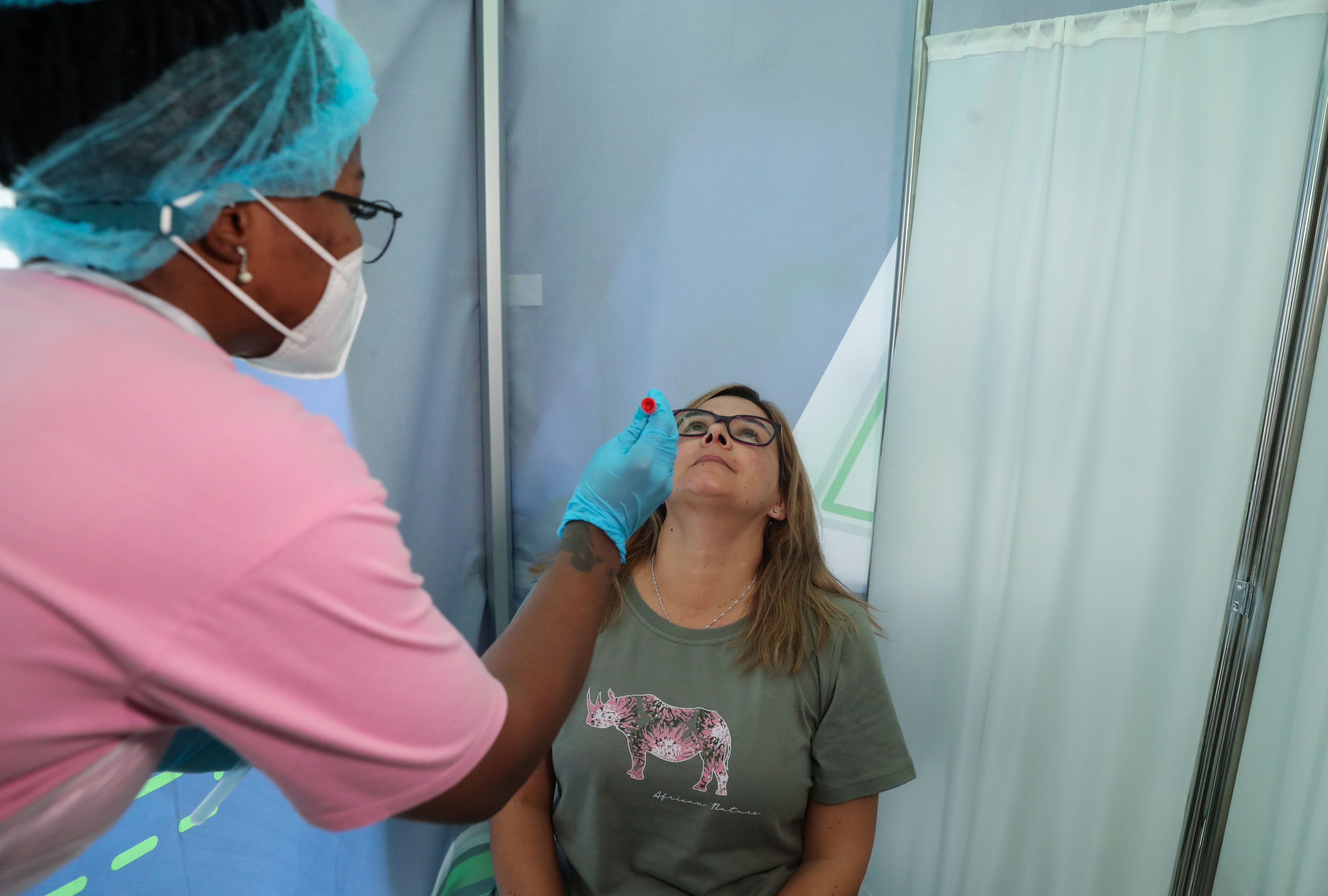 Healthcare worker collects a swab from Bronwen Cook for a PCR test against COVID-19 before traveling to London, at O.R. Tambo International Airport in Johannesburg