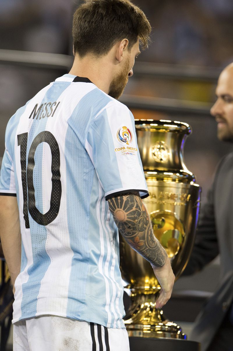 Lionel Messi pasa por el costado del trofeo de la Copa América Centenario.