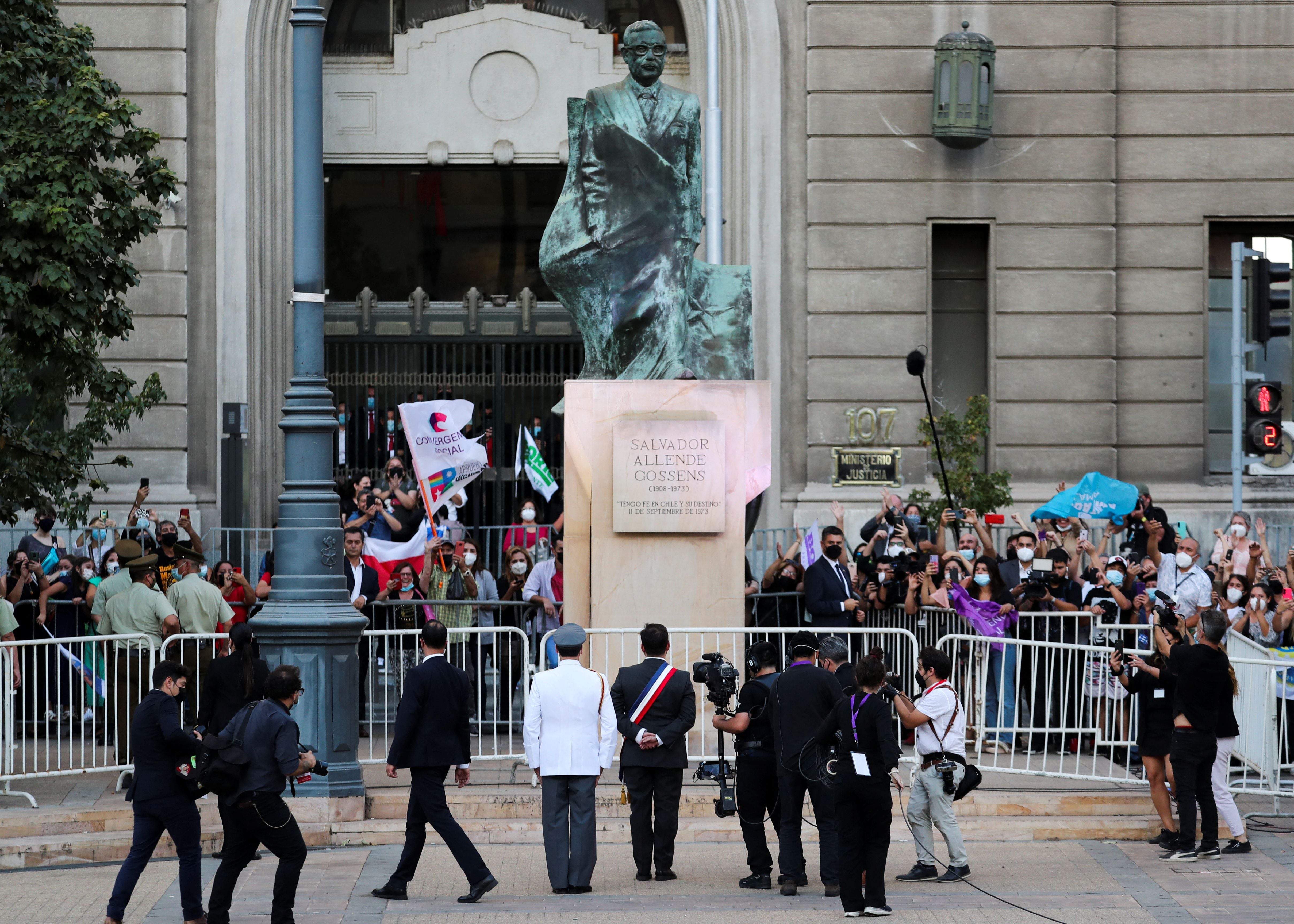 Chile's President Gabriel Boric stands in front of a monument of Chile's former president Salvador Allende in Santiago