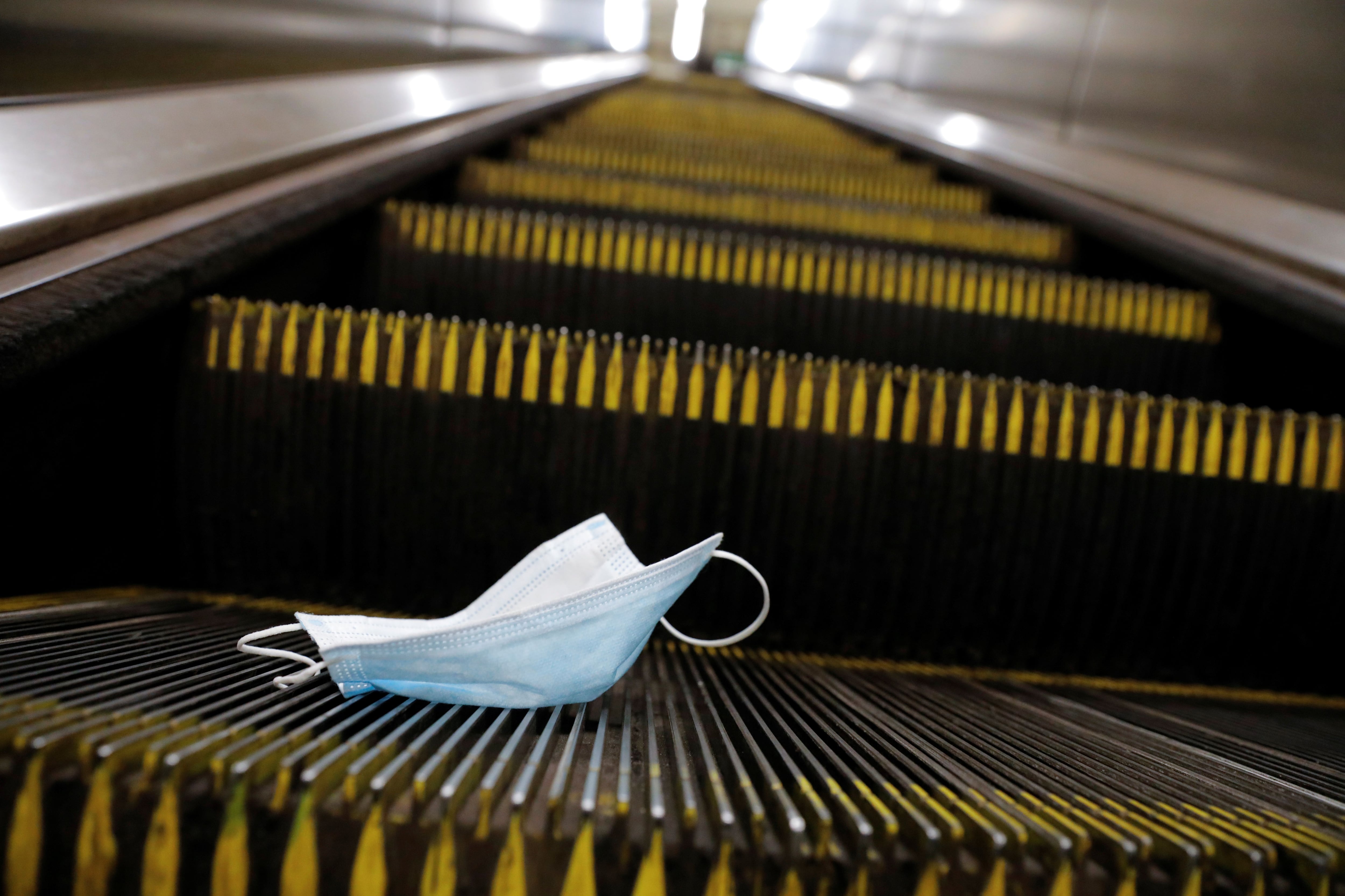 A protective mask is seen discarded on an escalator during the outbreak of the coronavirus disease (COVID-19) pandemic in Manhattan