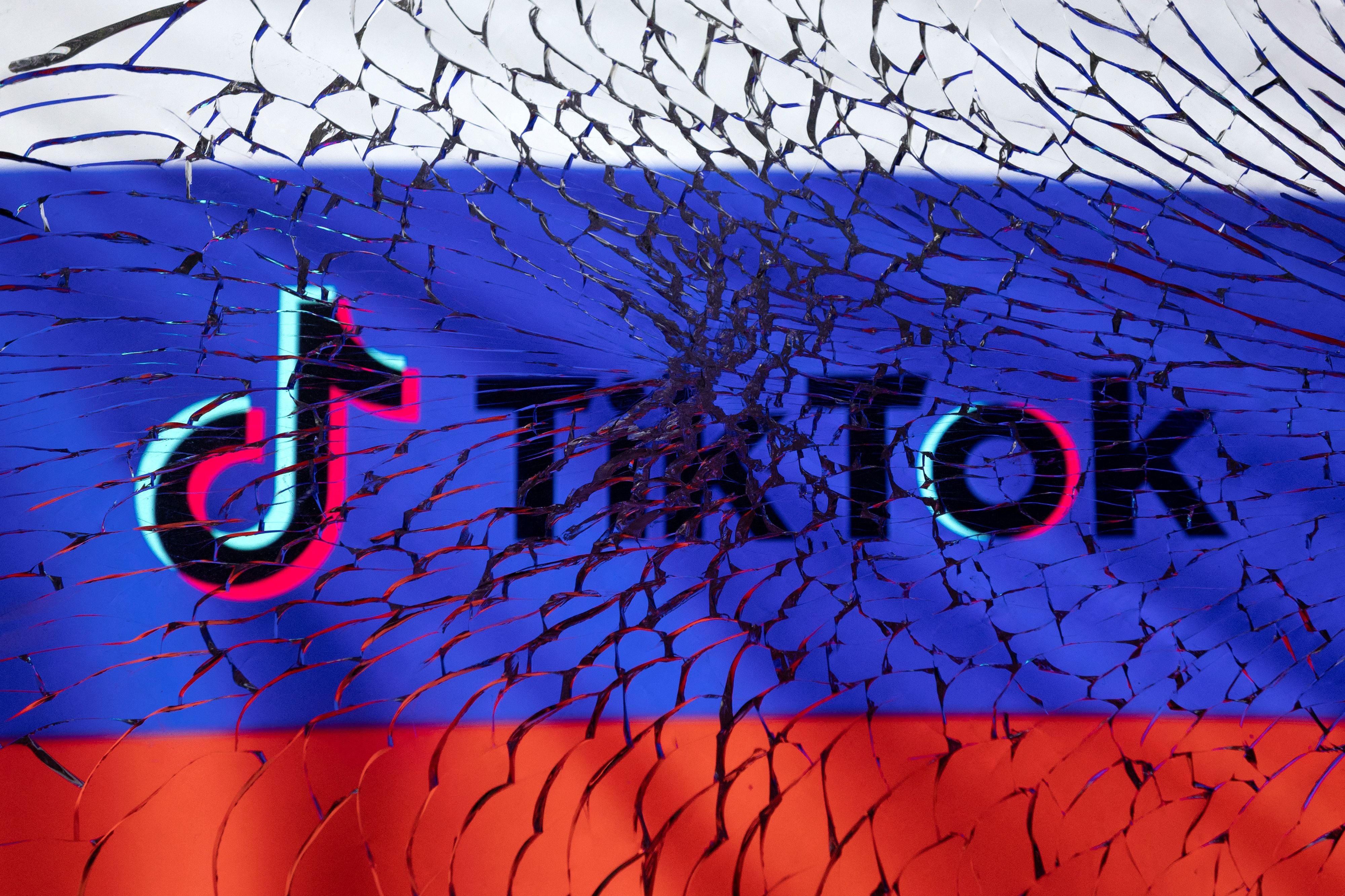 Illustration shows TikTok logo and Russian flag through broken glass