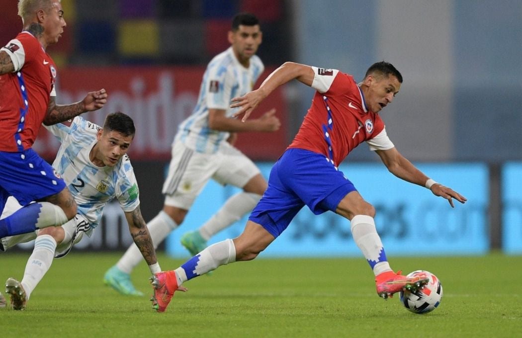 Alexis Sánchez se lleva el balón en el partido entre Argentina y Chile en Santiago del Estero