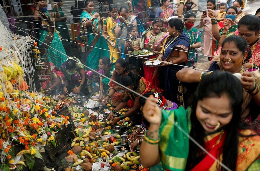 Hindu married women offer prayers and tie a thread around a banyan tree during the festival of Vat Purnima amid the spread of the coronavirus disease (COVID-19), in Mumbai