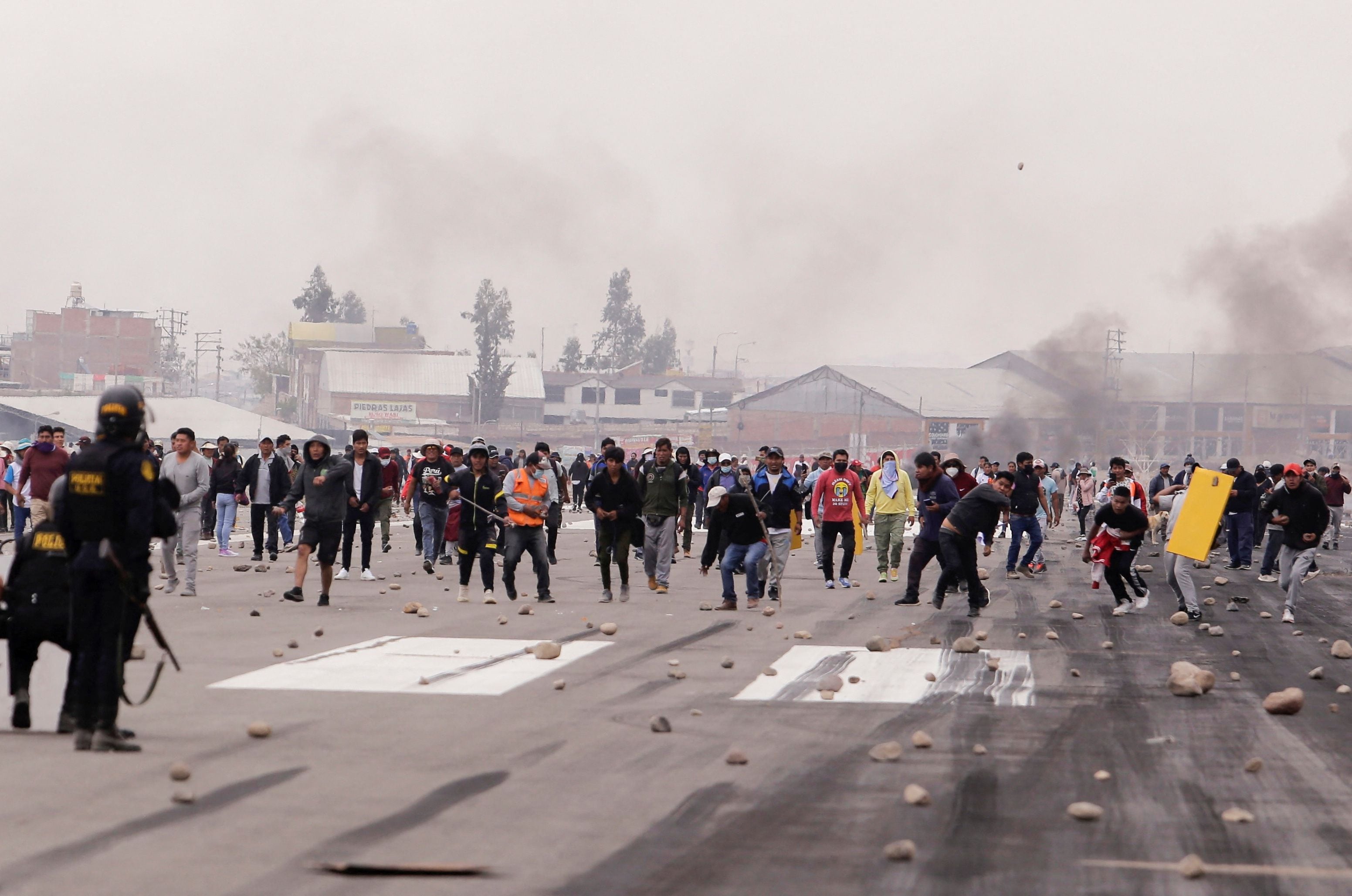 Police officers clash with demonstrators during a protest at the airport in Arequipa