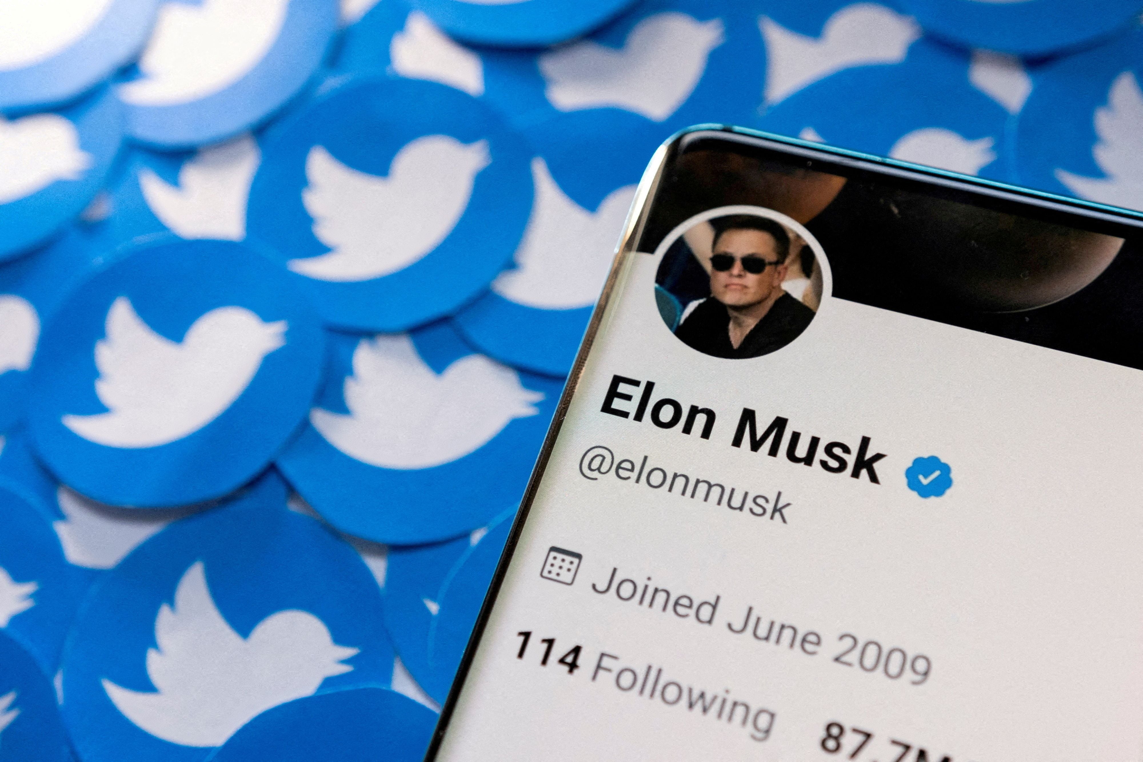 FILE PHOTO: Illustration shows Elon Musk's Twitter profile on smartphone and printed Twitter logos