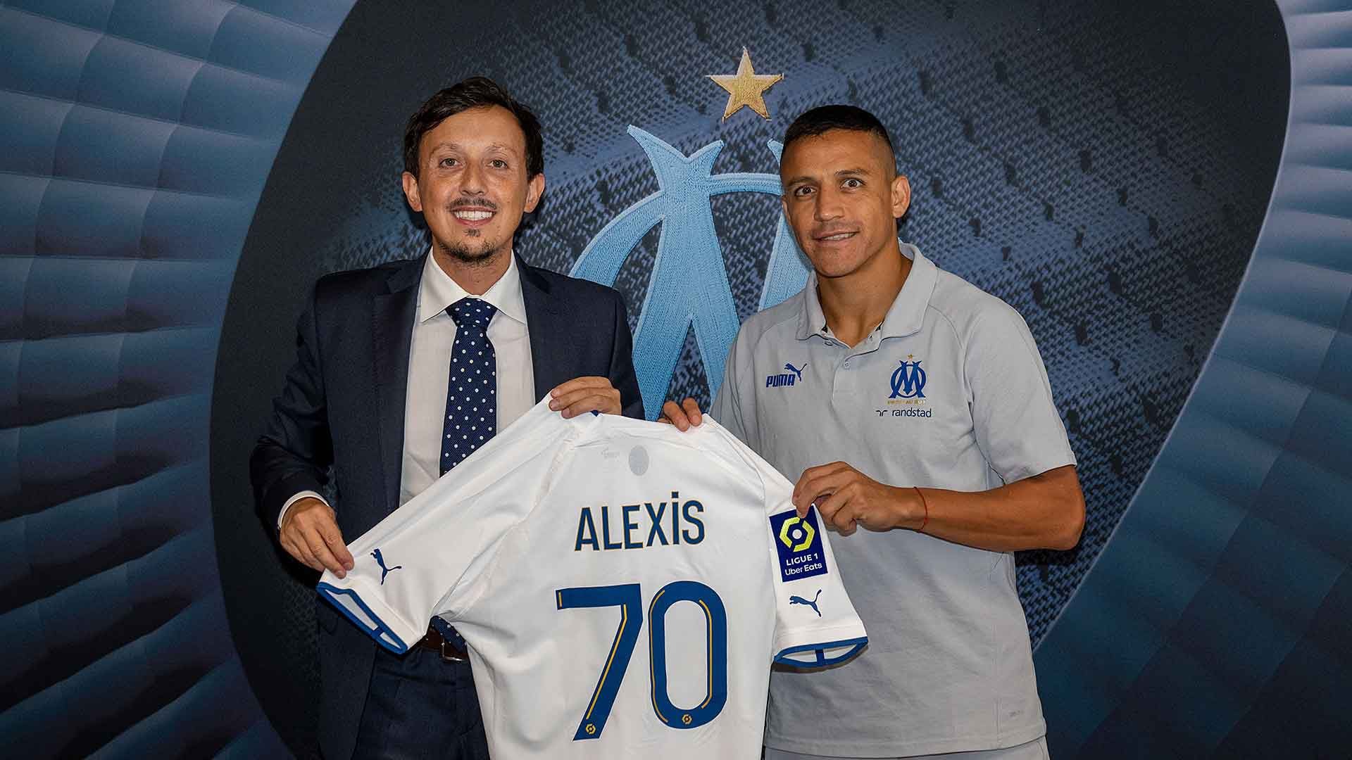 Alexis Sánchez sostiene la camiseta 70 del Olympique de Marsella junto al presidente del club Pablo Longoria.