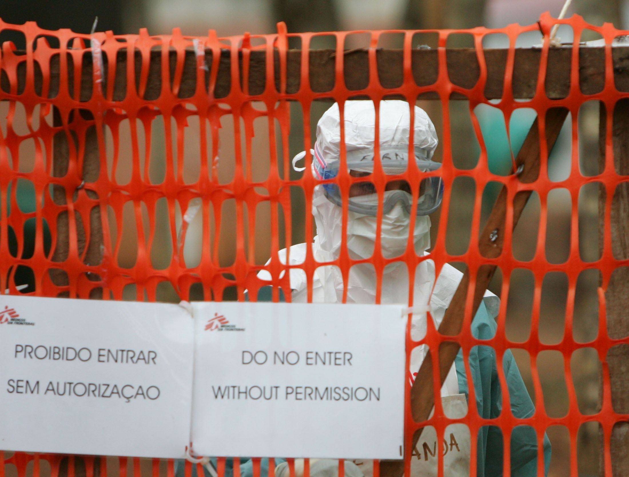 A health worker peers out from behind barriers marking the isolation ward where victims of the ...