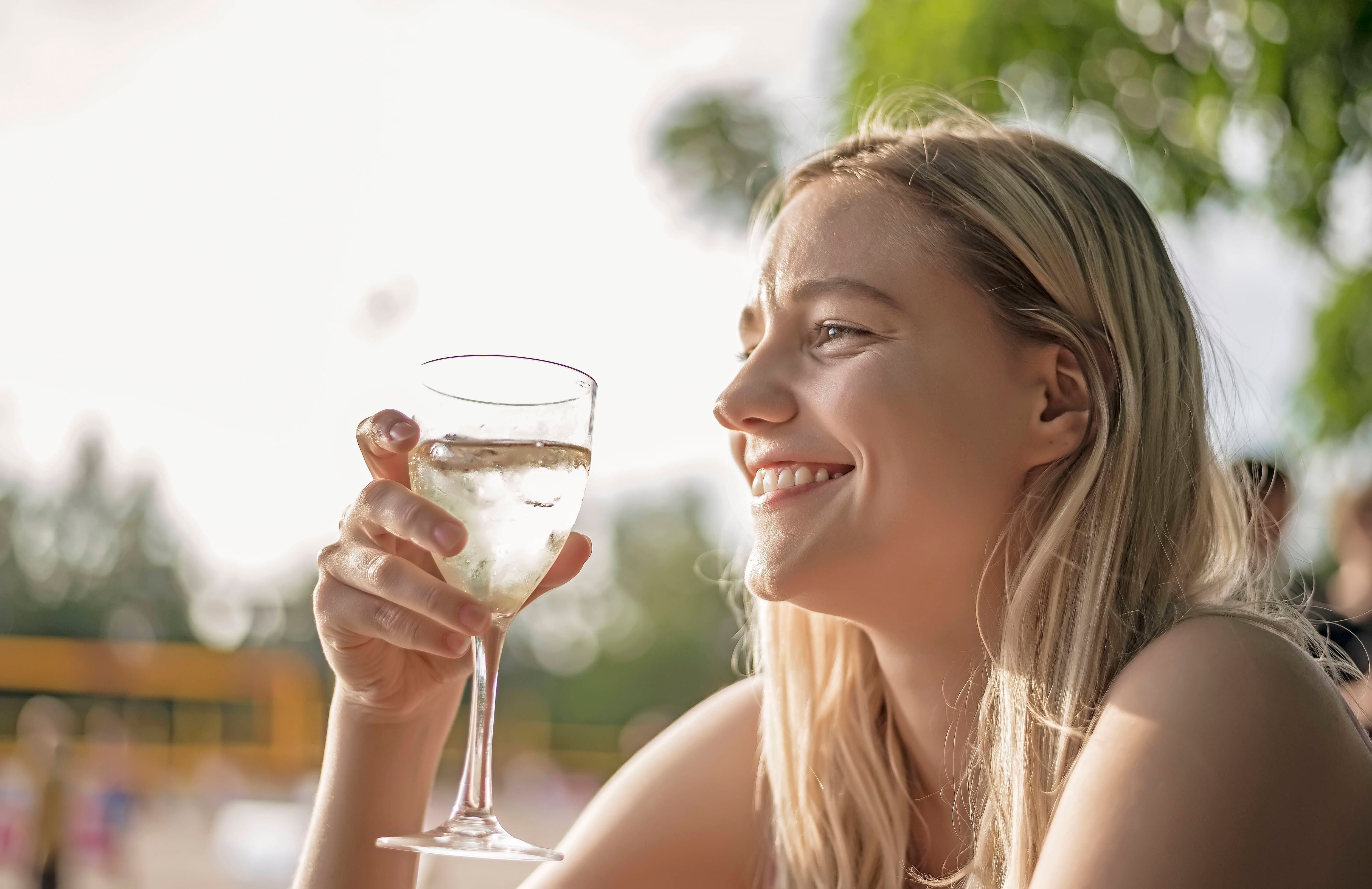 lachende junge Frau trinkt Wein *** laughing young woman drinking wine