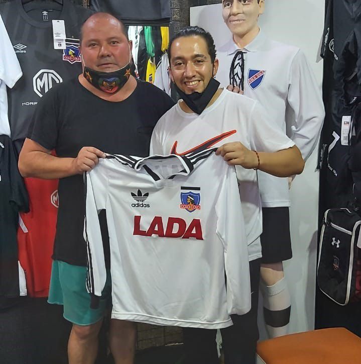 Juan Carlos Peralta posa junto a un hincha con la camiseta conmemorativa del título de 1991.