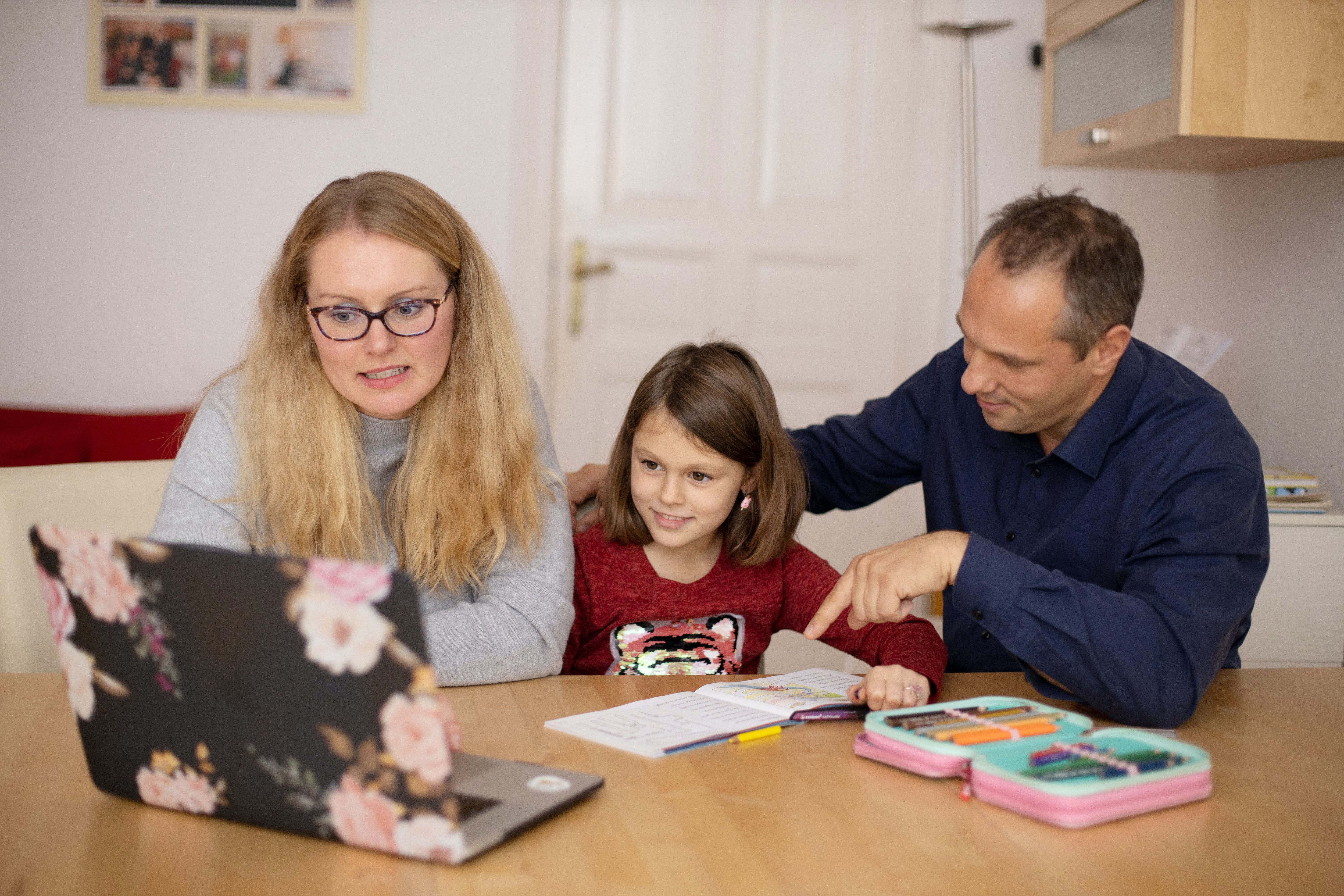 Padres e hija en el computador